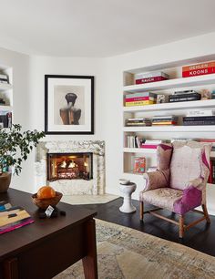 a living room filled with furniture and a fire place next to a bookshelf