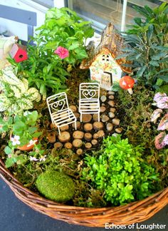 a basket filled with lots of different types of plants and small houses on top of it