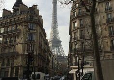 the eiffel tower towering over the city of paris, france as seen from an empty street