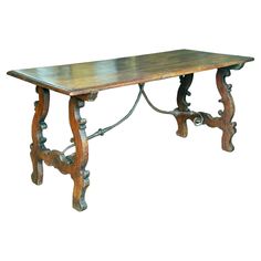 an old wooden table with ornate carvings on the top and legs, against a white background