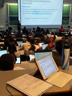 a classroom full of students with laptop computers