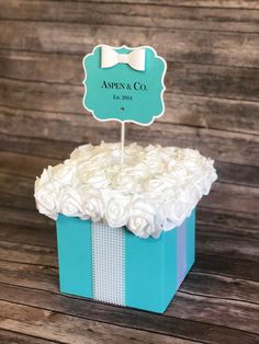 a blue box with white flowers and a bow tie on top that says apres & co