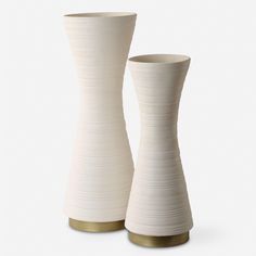 two white vases sitting next to each other