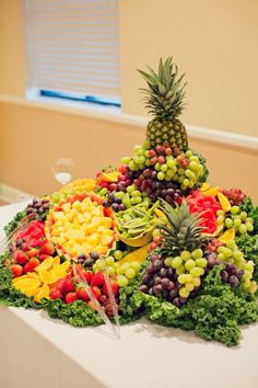 a table topped with lots of different types of fruits and veggies on top of each other