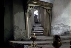 two vases sitting on the steps in an old building