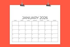 a calendar with the word january on it hanging from a clipping board against an orange background