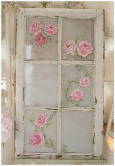 an old window with pink roses painted on it