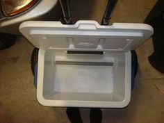 an ice chest sitting on the ground next to a motorcycle