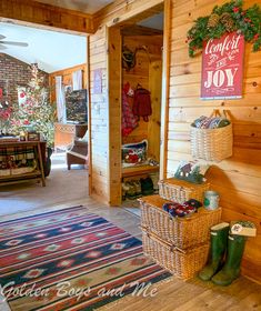 the inside of a log cabin with christmas decorations on the wall and baskets full of gifts