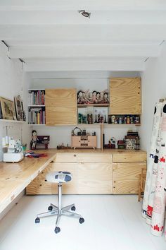 a kitchen with lots of wooden cabinets and white tile flooring, along with an office chair