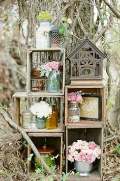 an assortment of vases and jars are arranged on shelves in front of a tree