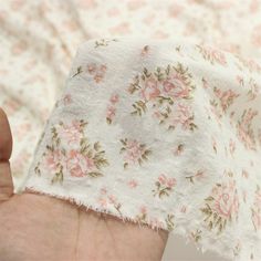 a hand holding a piece of cloth with flowers on it and chinese writing in the middle