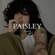 a woman with tattoos on her arm and chest sitting in bed next to the words paisley church