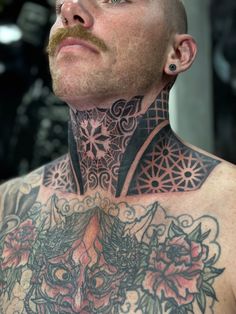 a man with tattoos on his chest and neck