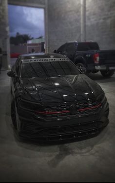 a black car parked in a garage next to other cars