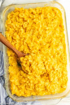 macaroni and cheese in a casserole dish with a wooden spoon