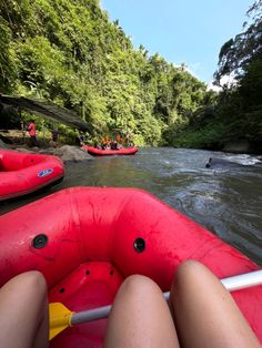 people are rafting down the river in red rafts