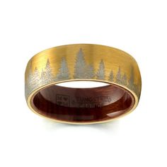 a gold and silver ring with trees on it