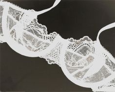 an old photo of a bra with lace on it's side, taken in black and white