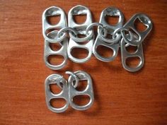 four pairs of metal clips sitting on top of a wooden table