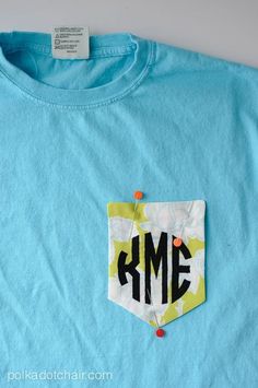 a blue t - shirt with the word kme on it's front pocket