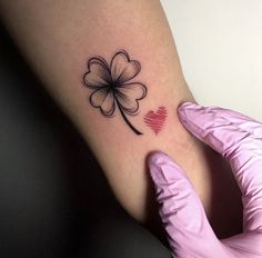 a person's foot with a clover tattoo on it and a heart in the middle