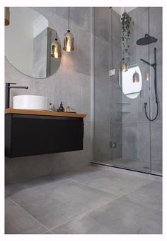 a bathroom with a sink, mirror and shower stall in it's center area