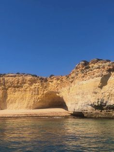 the beach is surrounded by cliffs and water