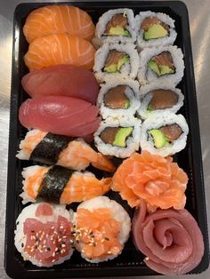 an assortment of sushi on a black tray