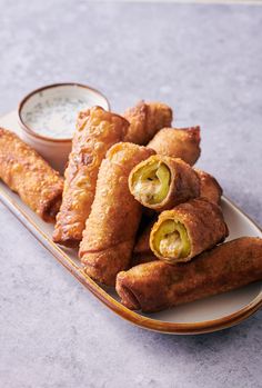 some food is sitting on a plate with dipping sauce