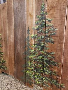 a wooden fence with pine trees painted on it