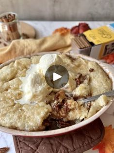 a bowl filled with mashed potatoes on top of a table next to other food