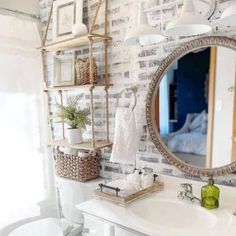 a bathroom with a sink, mirror and shelves on the wall next to a toilet