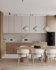 a modern kitchen with white chairs and wooden table