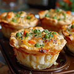 several small pies with peas and carrots on a brown tray, ready to be eaten