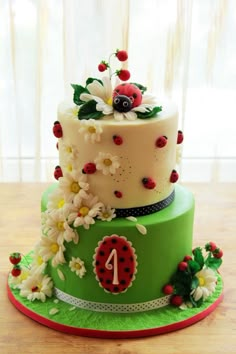 a three tiered cake decorated with ladybugs and daisies