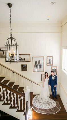 the bride and groom are posing on the stairs