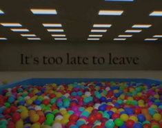 a room filled with lots of balls and a sign that says it's too late to leave