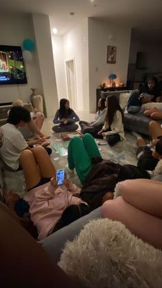 a group of people sitting on couches in a living room watching something on tv