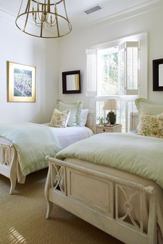 two beds in a bedroom with white walls and carpeted flooring next to windows