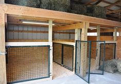 the inside of a barn with hay in it