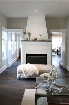 a living room filled with furniture and a fire place in the middle of a room