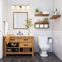 a white toilet sitting next to a wooden sink vanity in a bathroom under a mirror