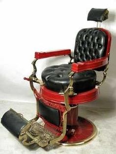 a red and black barber chair sitting on top of a white floor next to a wall