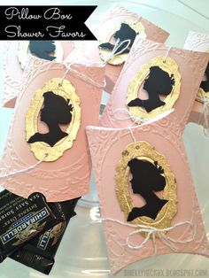 some pink and gold paper bags with black silhouettes on them