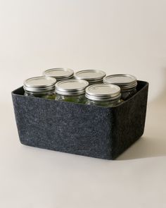 six mason jars sitting in a black container