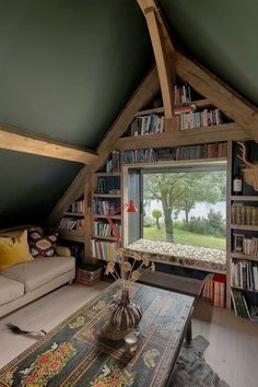 a living room filled with lots of furniture and bookshelves next to a window