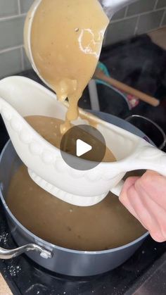 a person pouring liquid into a pot on top of a stove with a spatula