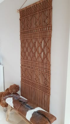 a brown and white rug sitting on top of a wooden bench next to a teddy bear