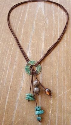 a necklace with stones and beads on a wooden surface